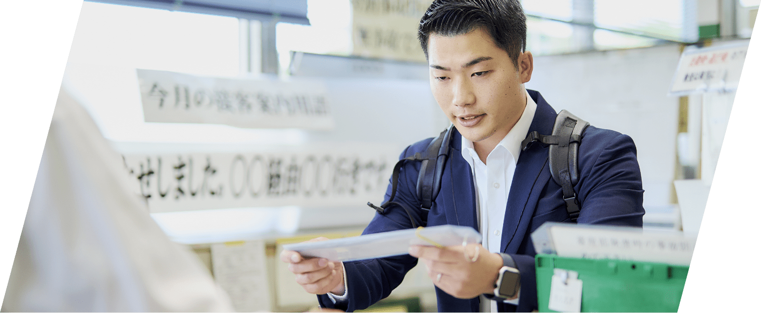 事務所で資料を手に持つスーツ姿の男性