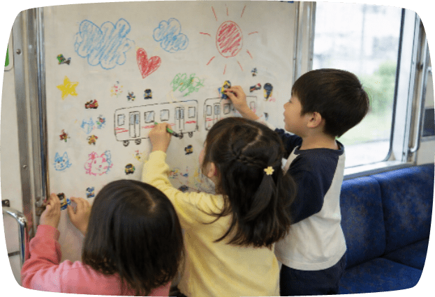 電車の車内の壁にお絵かきをするこども